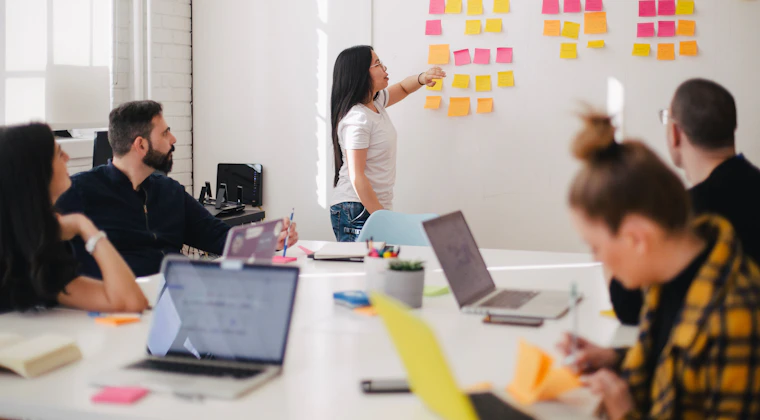 A team planning content around a wall of sticky notes